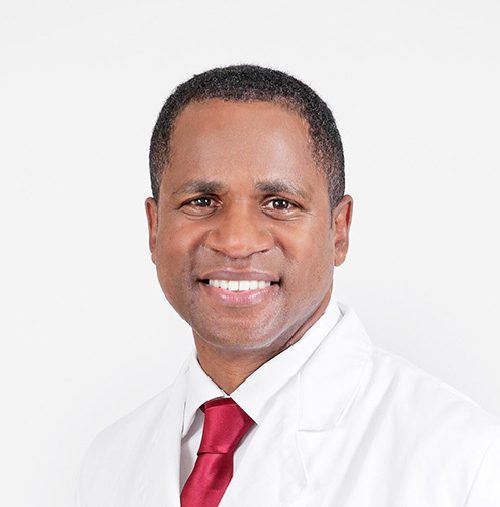 Man wearing a red tie and white coat.